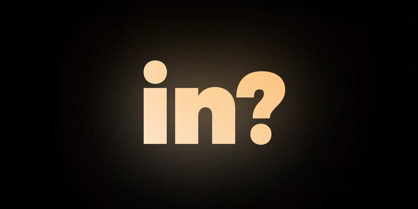 The preposition "in" with a question mark. The text is orange and bright. It is placed on a dark background.